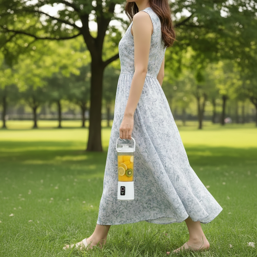 femme qui transporte son blender smoothie mangue citron kiwi par la poignée en se promenant dans le parc